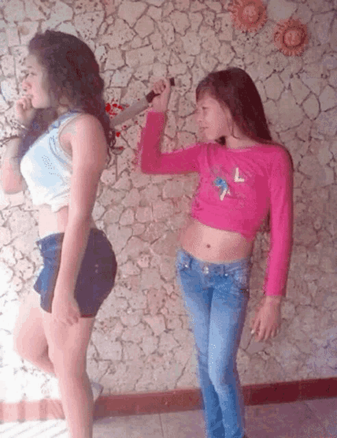 a girl in a pink crop top with the letter l on it