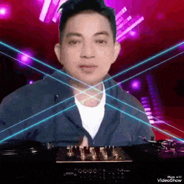 a man is standing in front of a mixer with purple lights behind him