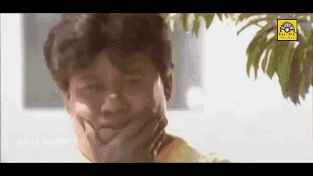 a man in a yellow shirt is making a funny face with his hand on his chin