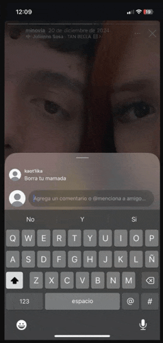 a phone screen shows a man and a woman and a keyboard