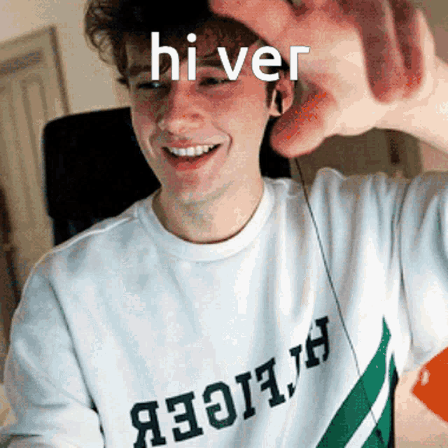 a man wearing a shirt that says hi ver is smiling