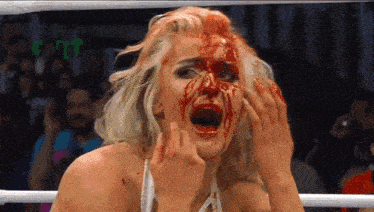 a woman with blood on her face is in a ring .