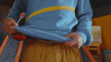 a person in a blue shirt is holding a light on their chest