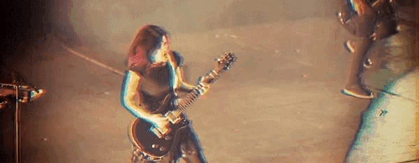 a woman is playing a guitar on a stage in front of a microphone