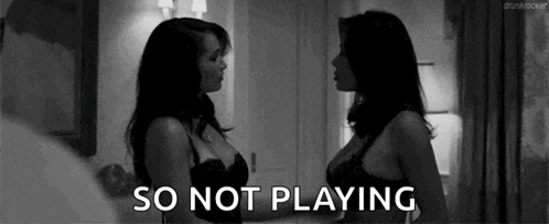 two women in lingerie are standing next to each other and the words `` so not playing '' are visible .