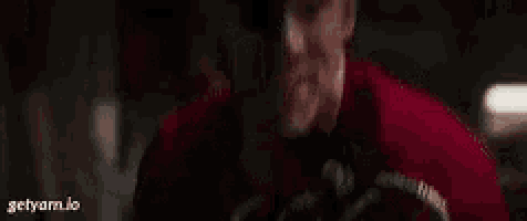 a close up of a man in a red shirt eating something .