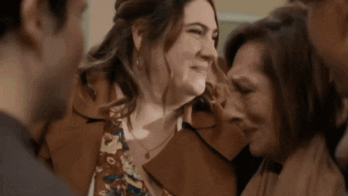 a group of people are standing around a woman who is crying and smiling