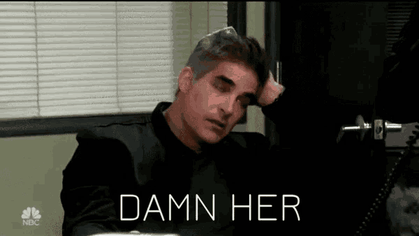 a man is sitting at a desk with his hand on his head and the words " damn her " written above him