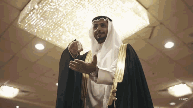 a man in a white and gold robe is standing in front of a chandelier and the word daisy is on the bottom