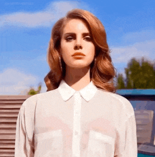 a woman wearing a white shirt with a white collar stands in front of a blue sky