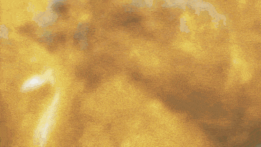 a person in a yellow suit is standing on a sidewalk with smoke coming out of their mouth