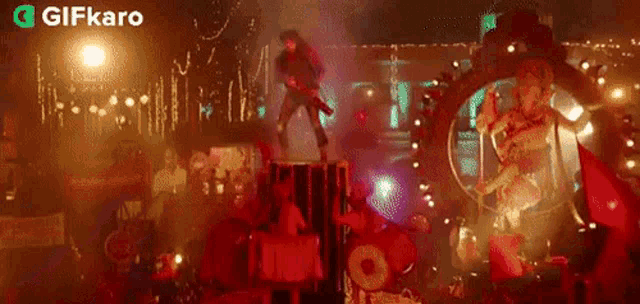 a man is standing on a stage holding a guitar in front of a crowd .