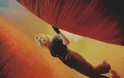a woman in a black shirt is laying on a red blanket