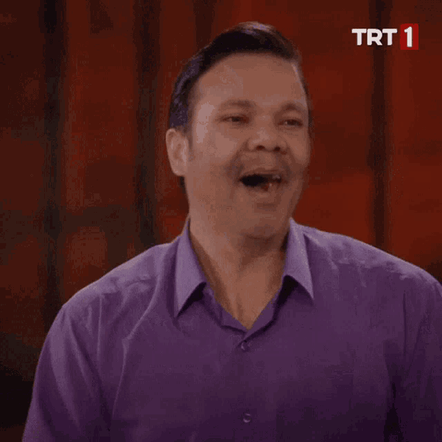 a man in a purple shirt with trt 1 on the bottom right
