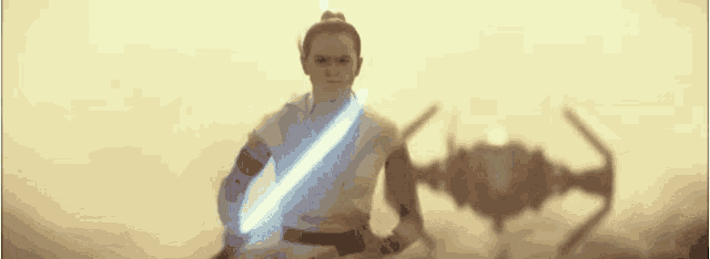 a woman is holding a light saber in front of a shadow of a star wars ship .