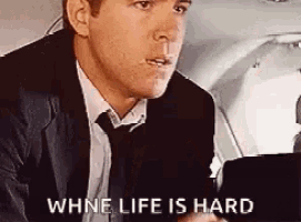 a man in a suit and tie is sitting in the cockpit of an airplane .