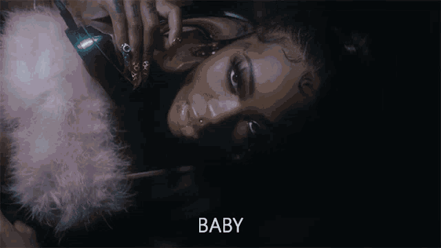 a woman in a pink feathered coat is laying down and the word baby is on the bottom