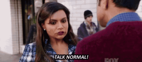 a man and a woman are talking to each other and the woman is telling the man to talk normal .