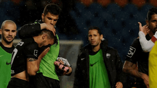 a group of soccer players one of whom is wearing a green vest that says eco