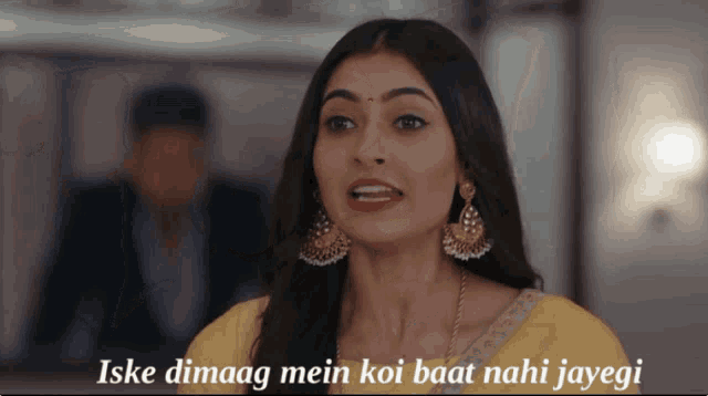 a woman in a yellow dress says iske dimaag mein koi baat nahi jayegi