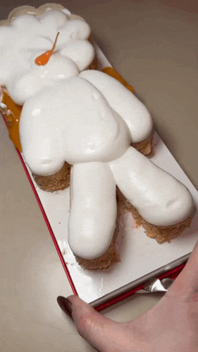 a cake in the shape of a teddy bear with white frosting on it