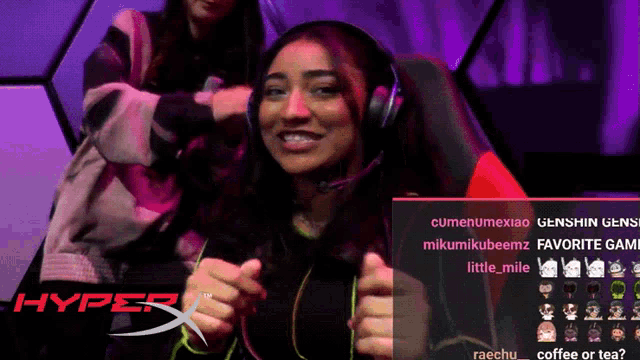 a woman wearing headphones is smiling in front of a hyper x logo