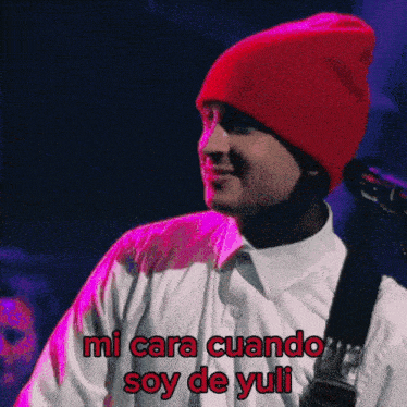 a man wearing a red beanie and a white shirt says mi cara cuando soy de yuli