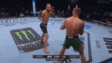 two fighters are fighting on a ufc ring with a monster energy can in the background