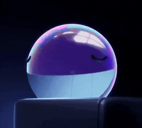 a purple and blue ball with a face on it is sitting on a table .