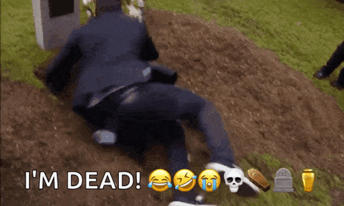 a man is laying on the ground in front of a grave with the words i 'm dead written on the ground