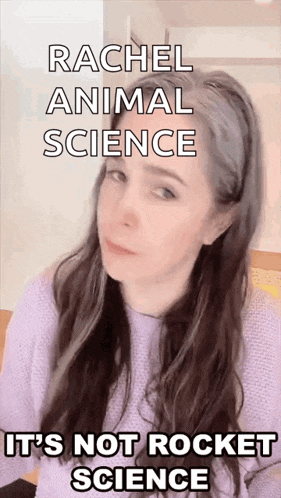 a woman with long hair is wearing a purple sweater and making a funny face while talking about animal science