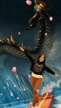 a woman wearing a calvin klein shirt is standing on a surfboard in front of a dragon