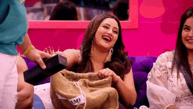 a woman is laughing while holding a bag that says ami