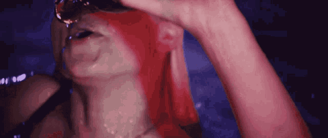 a woman with red hair is drinking water from a glass