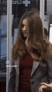 a woman with long hair is standing in front of a sign that says spain_leonor