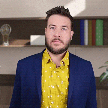 a man with a beard wearing a blue jacket and a yellow polka dot shirt