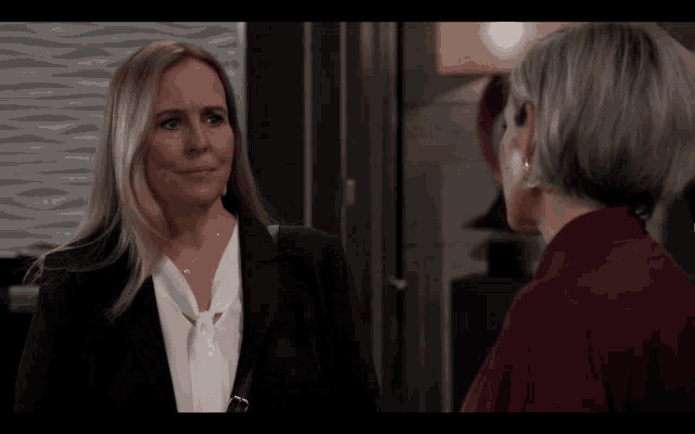 two women are standing next to each other and talking to each other