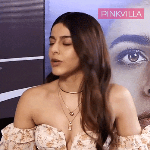 a woman stands in front of a poster that says pinkvilla on it