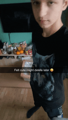 a boy wearing a black shirt with a wolf on it has felt cute might delete later written on it