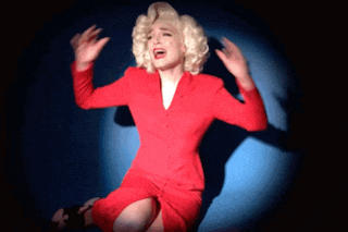 a woman in a red suit and blonde hair is screaming