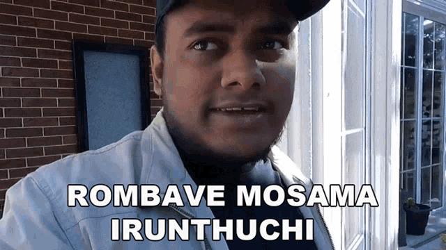 a man wearing a hat and a jacket with the words rombave mosama irunthuchi above him