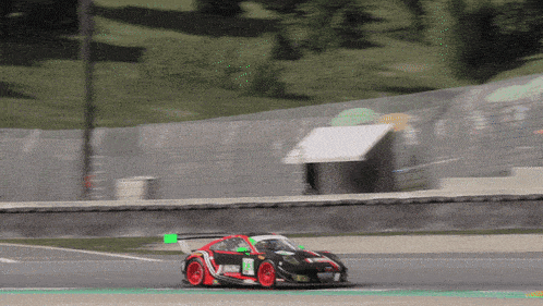 a red and black race car with the number 22 on the side is driving down a track