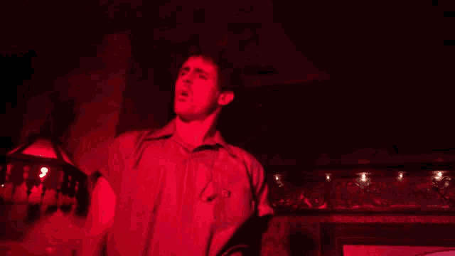 a man in a red shirt has a badge on his chest that says ' a ' on it