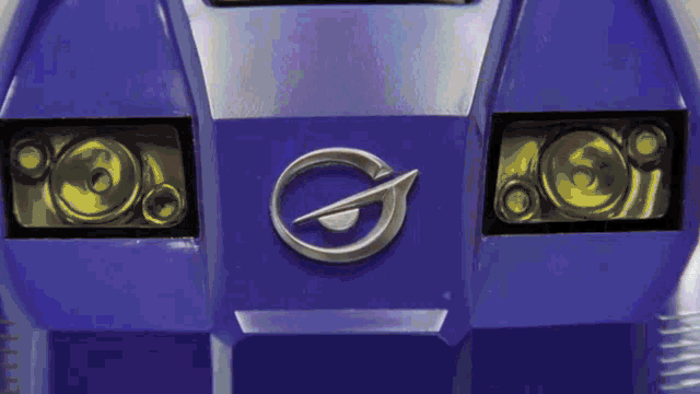 a close up of the front of a blue vehicle with a silver logo
