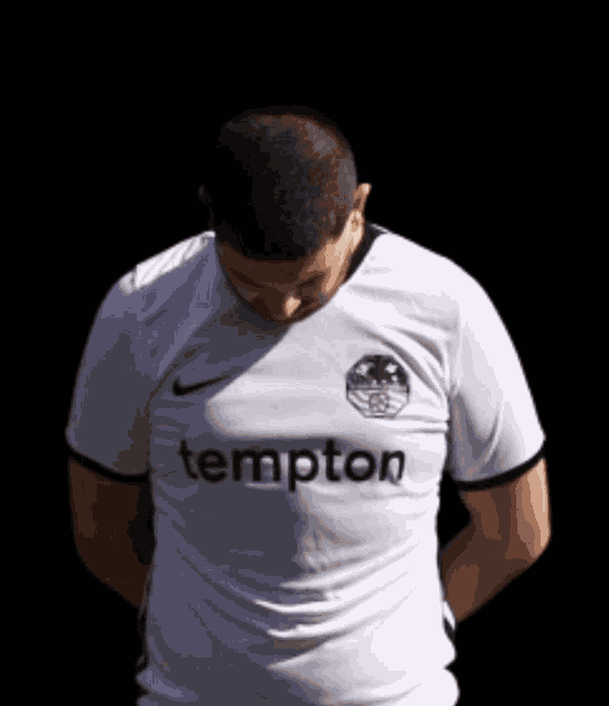 a man wearing a white shirt that says tempton on it