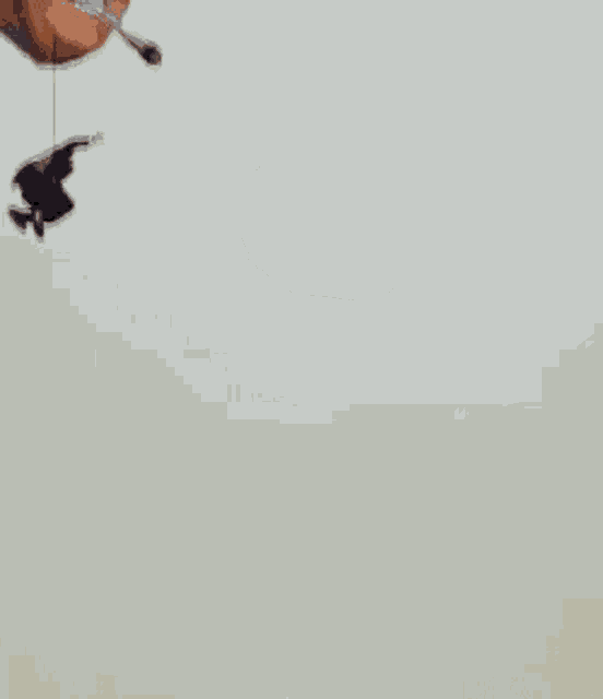 donald trump is wearing sunglasses and smoking a cigarette while a man is hanging from a parachute .