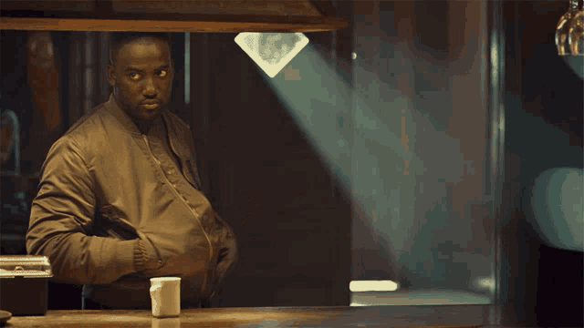 a man in a brown jacket stands in front of a counter