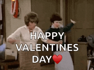 a couple of women are dancing in a room with the words `` happy valentines day '' written on the screen .