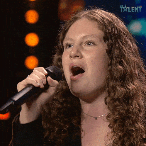 a woman singing into a microphone with the word talent on the bottom right