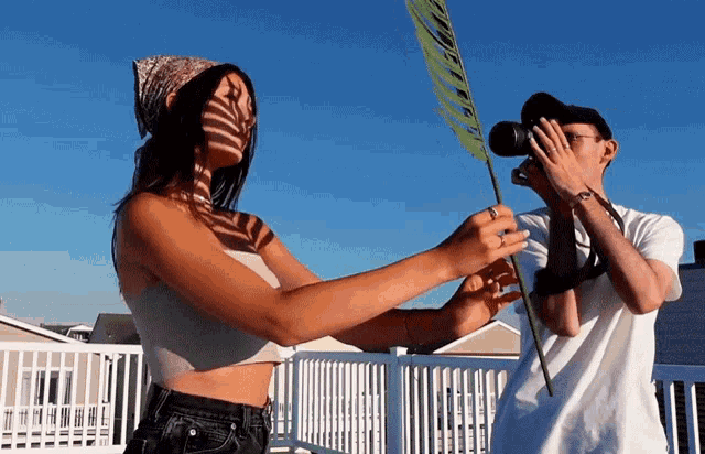 a man is taking a picture of a woman holding a sign that says " no selfies "
